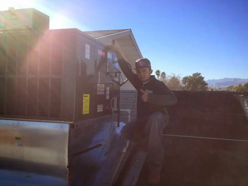 HVAC technician performing HVAC Inspection on a rooftop unit in Palmdale